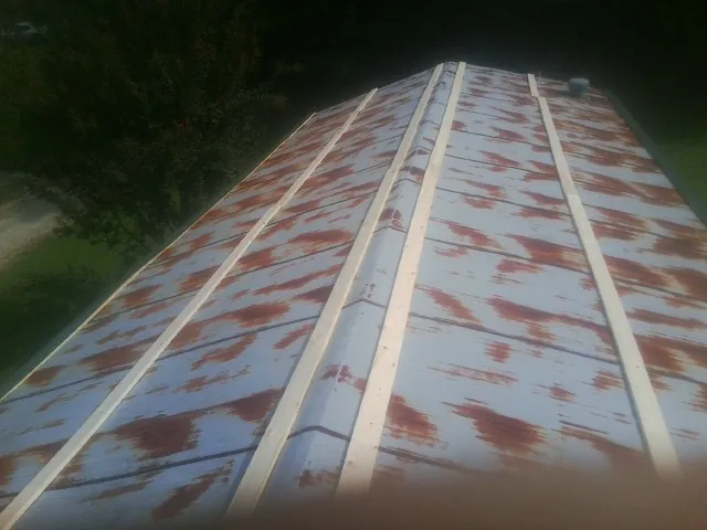 Rusted metal roof panels with new wood purlins before replacement — Storm Damage Roof Repair in Roy by Roofing Brothers